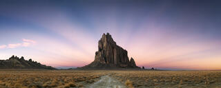 Magnificent light rays spread over Shiprock New Mexico casting a magnificent sight and a sense of awe.