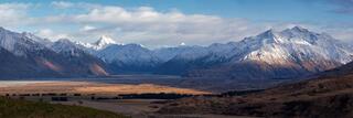 The Rangitata Valley in winter, golden tussock and braided river below the snow-covered peaks of the Southern Alps, New Zealand.
