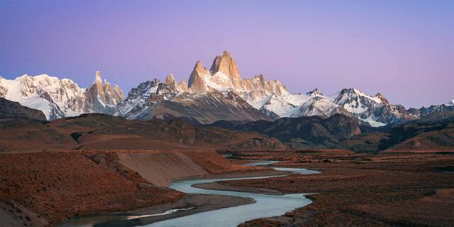 Monte Fitz Roy and Cerro Torre lit at sunrise above a braided river in the Patagonian steppe, Los Glaciares National Park, Argentina.