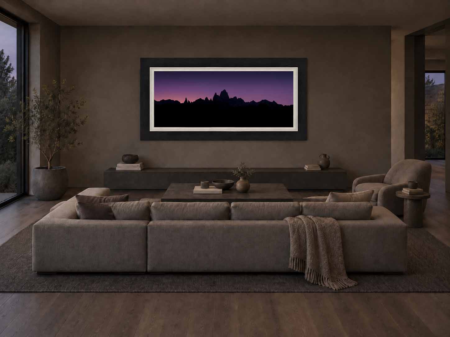 Mount Fitz Roy in silhouette against a violet twilight sky in Patagonia, framed in black with a white linen liner above a bench in a dark sitting room