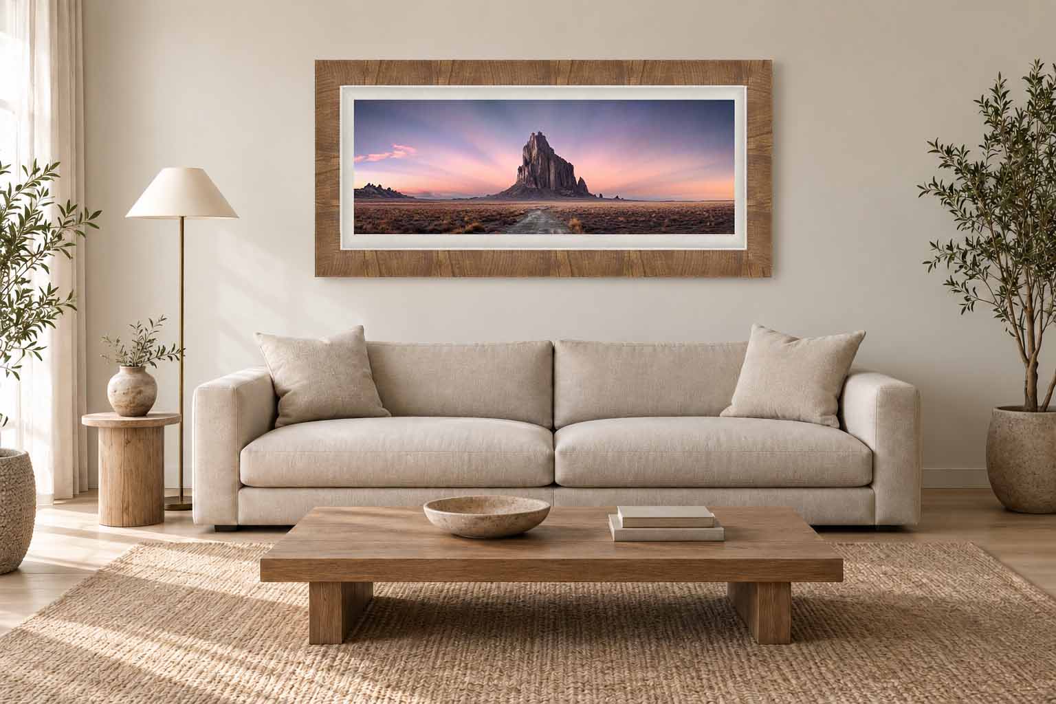 Ascension, a panoramic photograph of Shiprock at dusk, shown at true scale above a sofa in a living room.