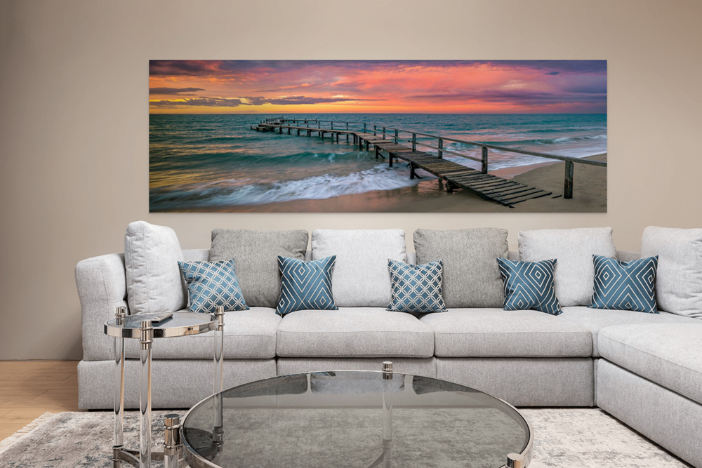 The Heaven's Door panorama at 30 by 90 inches, hanging above a pale sectional sofa in a living room.