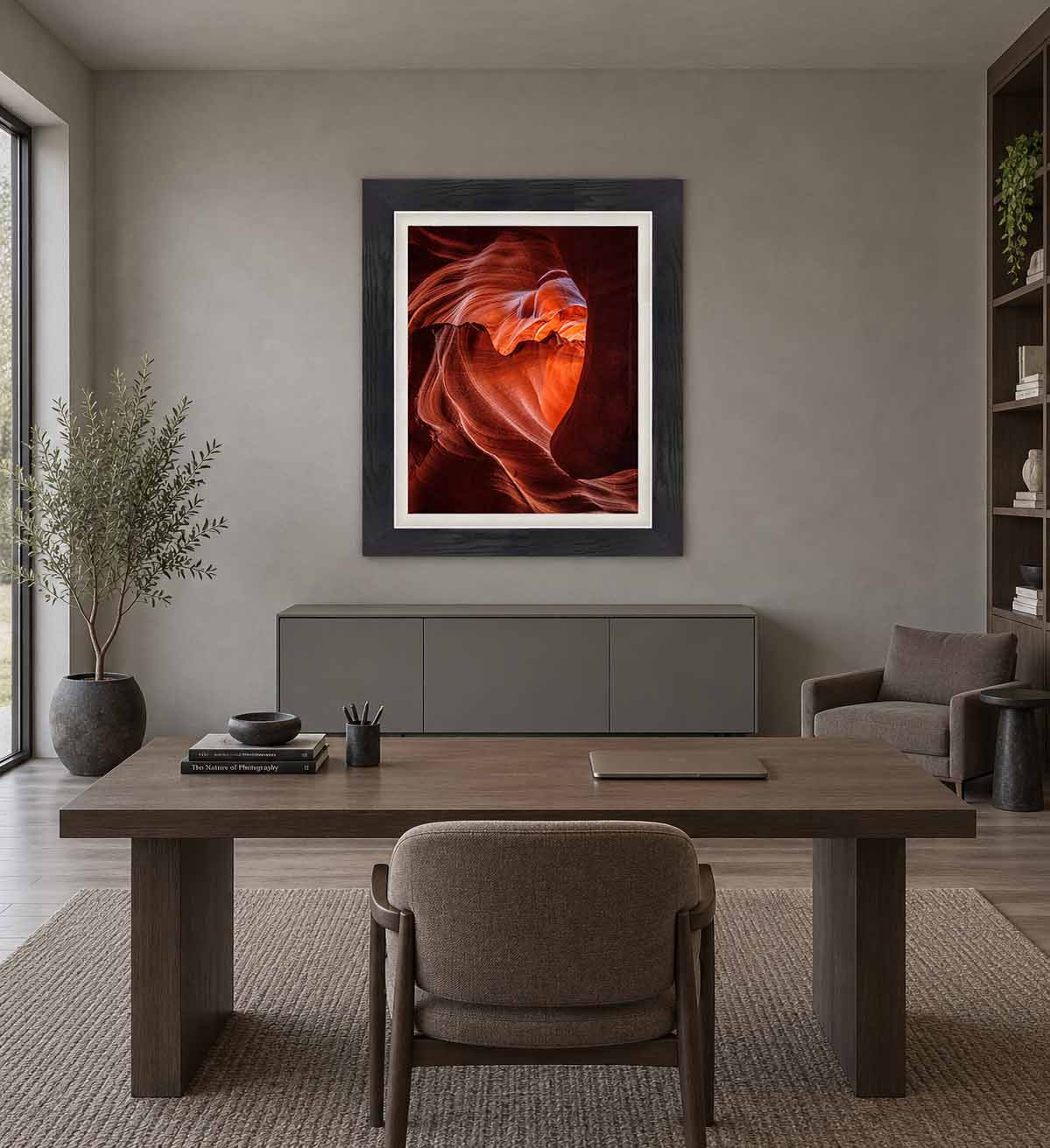 A heart-shaped formation in the sandstone of Upper Antelope Canyon, framed in black with a white linen liner above a credenza in a gray office