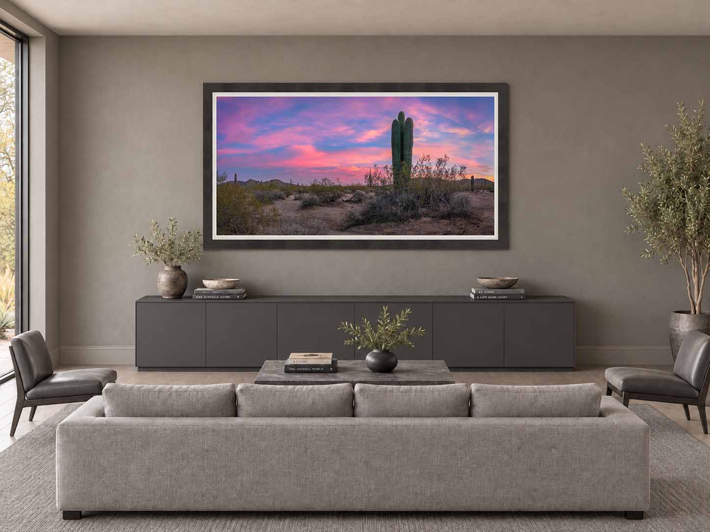 Saguaros beneath a pink dusk sky in the Sonoran Desert, framed in dark gray with a white linen liner above a credenza in a living room