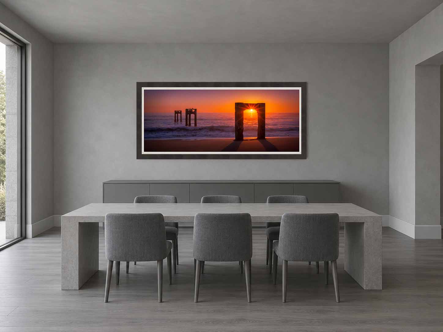 The Davenport Pier ruins at sunset on the California coast, framed in charcoal with a white linen liner above a sideboard in a gray dining room