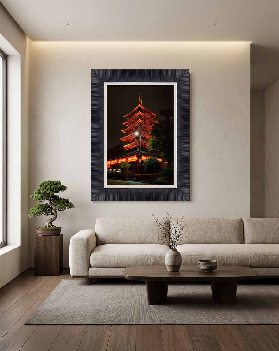 The five-storied pagoda at Sensō-ji lit at night in Asakusa, framed in charcoal with a white linen liner above a stone bench in a dark entry