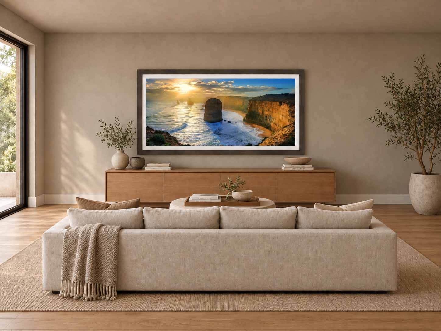 The Twelve Apostles at sunset on the Great Ocean Road in Victoria, framed in dark walnut with a white linen liner above a credenza in a warm living room