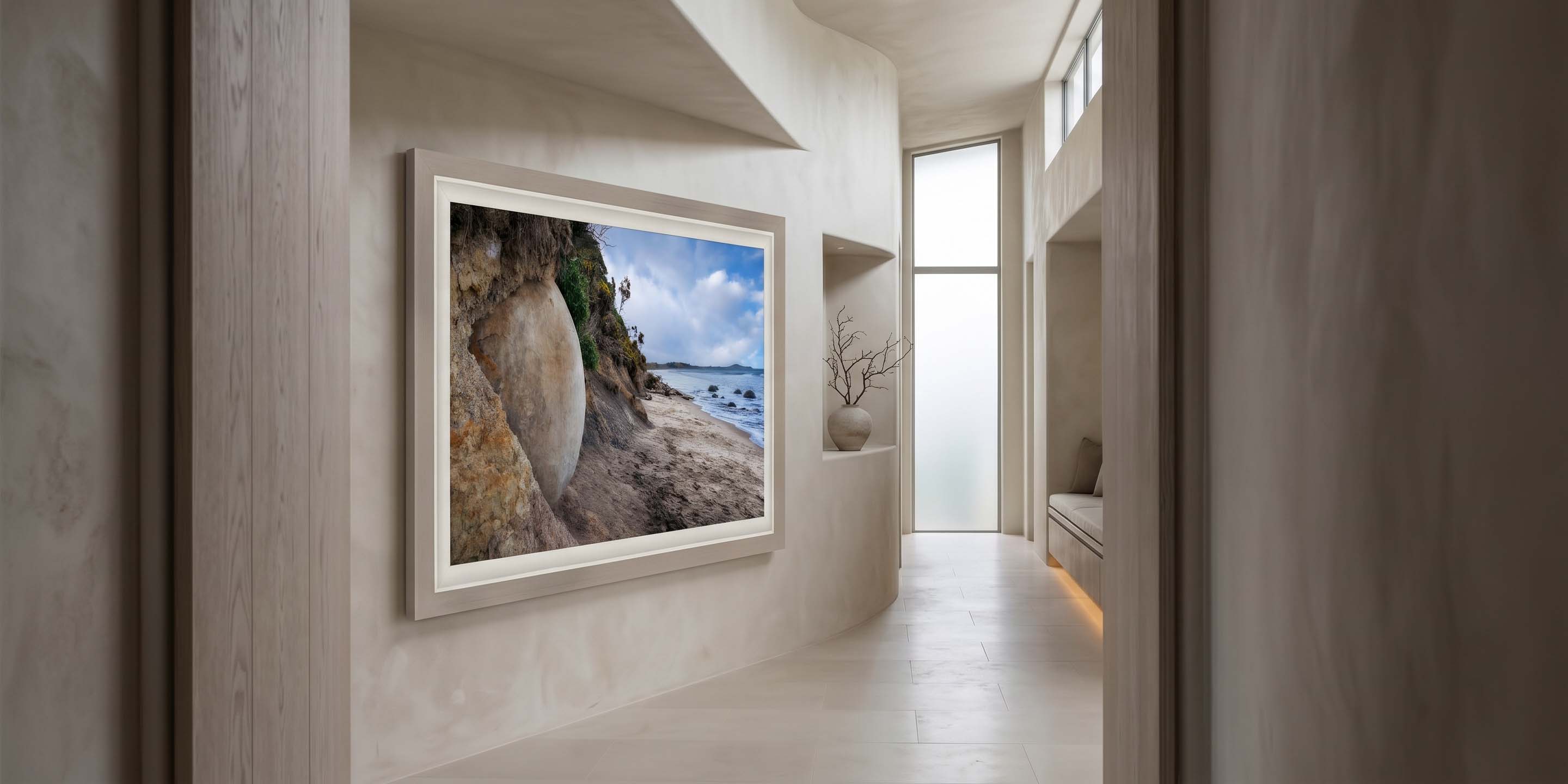 The Watcher displayed on a curved plaster wall in a light-filled hallway, framed in Ramino Night Silver with a white linen liner