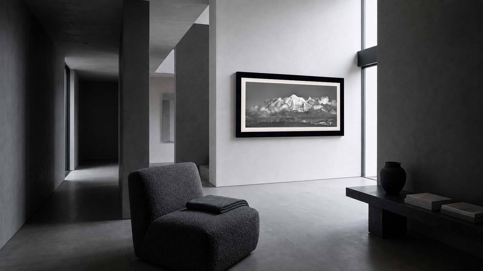 Unmoored shown as a framed black and white print on a plaster wall in a stone hallway, in a Moda Satin Black moulding with a white linen liner