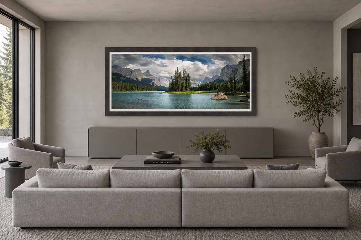 Spirit Island and Maligne Lake beneath the Canadian Rockies, framed in charcoal with a white linen liner above a credenza in a gray living room